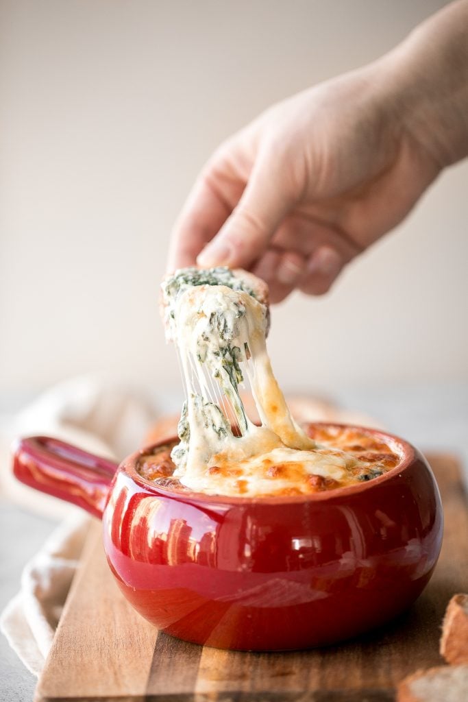 Warm, rich, creamy baked spinach dip is a delicious and easy appetizer that is baked until warm and melty. Easy to make ahead and a total crowd pleaser. | aheadofthyme.com