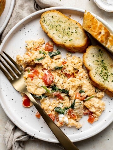 Mediterranean Scrambled Eggs with spinach, tomato, and feta is loaded with flavor and a quick and easy breakfast to make in under 10 minutes (with prep!). | aheadofthyme.com