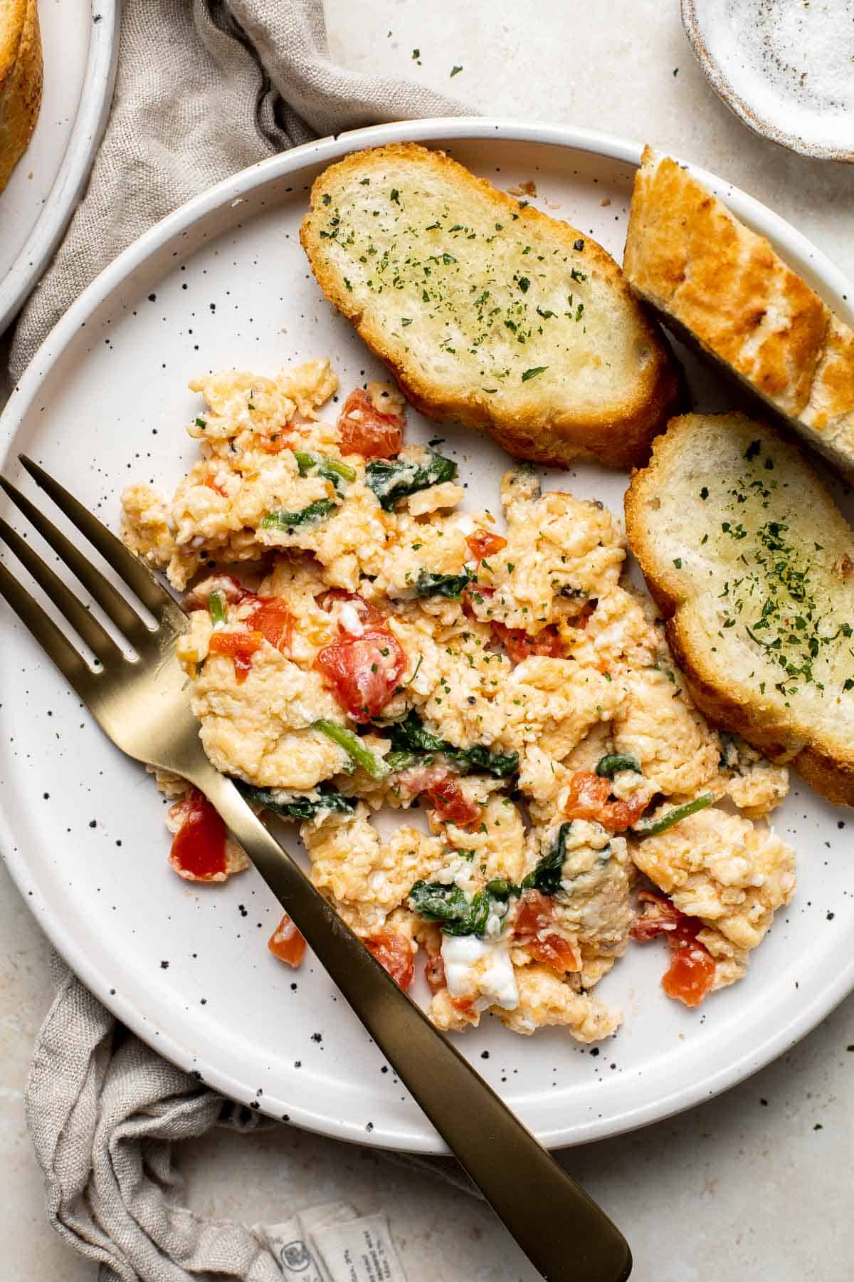 Mediterranean Scrambled Eggs with spinach, tomato, and feta is loaded with flavor and a quick and easy breakfast to make in under 10 minutes (with prep!). | aheadofthyme.com