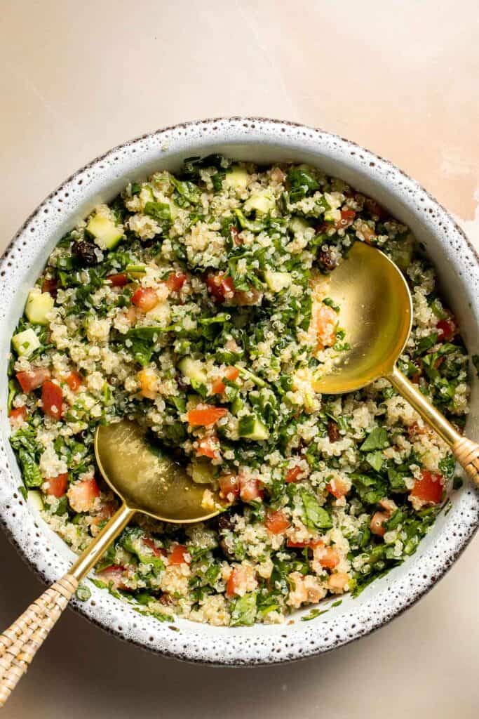 Quinoa Spinach Power Salad is made with tender quinoa, tomatoes, cucumbers, and raisins dressed in a homemade lemon vinaigrette. Gluten-free and vegan too. | aheadofthyme.com