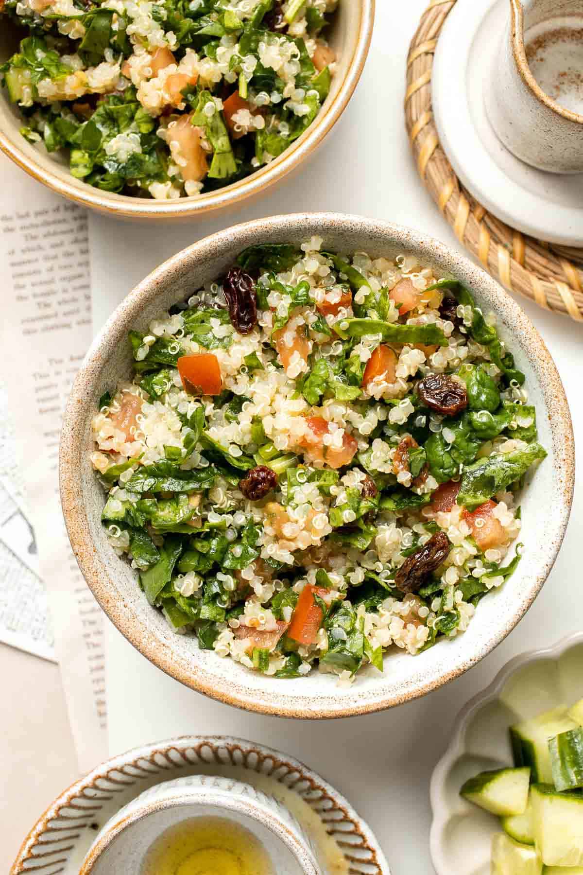 Quinoa Spinach Power Salad is made with tender quinoa, tomatoes, cucumbers, and raisins dressed in a homemade lemon vinaigrette. Gluten-free and vegan too. | aheadofthyme.com