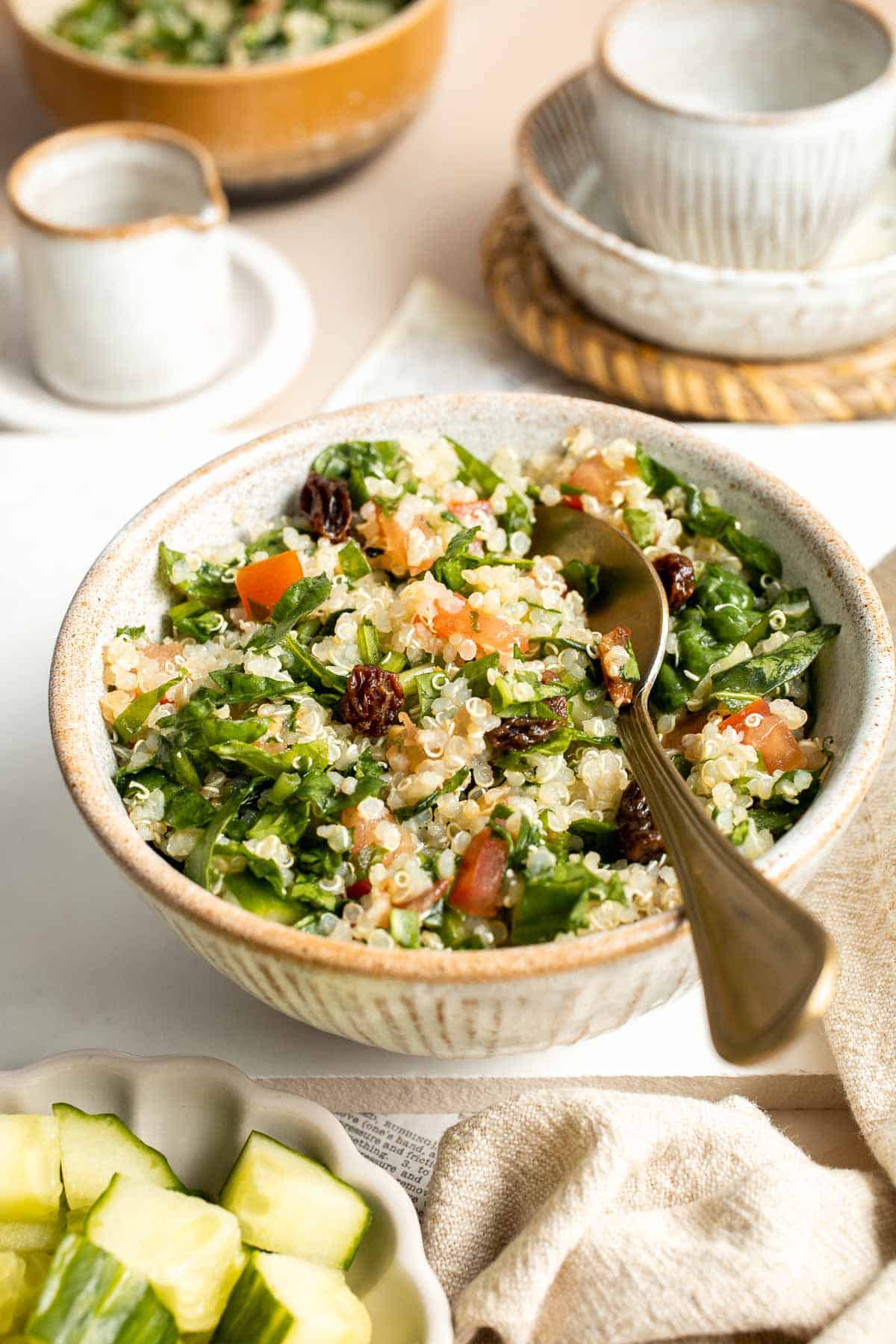 Quinoa Spinach Power Salad is made with tender quinoa, tomatoes, cucumbers, and raisins dressed in a homemade lemon vinaigrette. Gluten-free and vegan too. | aheadofthyme.com