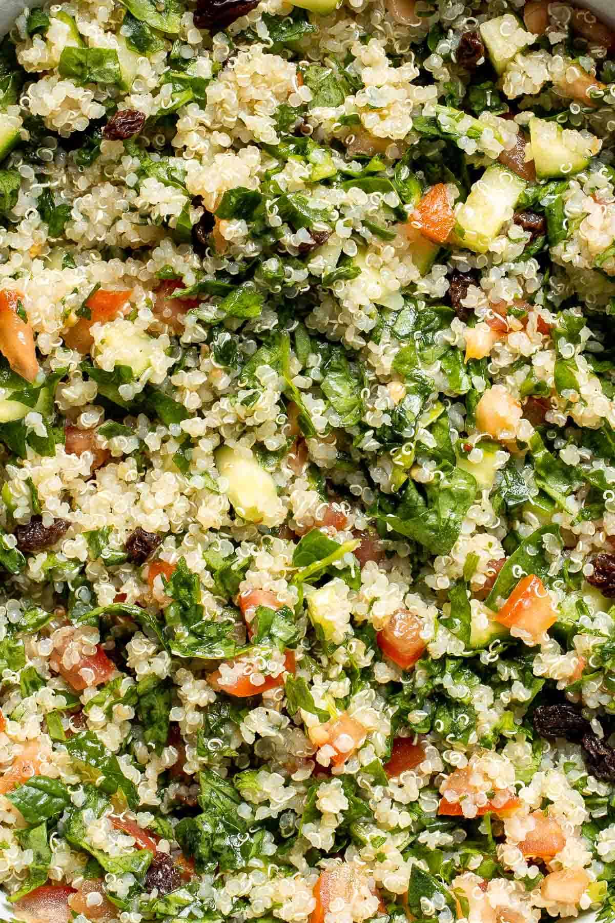 Quinoa Spinach Power Salad is made with tender quinoa, tomatoes, cucumbers, and raisins dressed in a homemade lemon vinaigrette. Gluten-free and vegan too. | aheadofthyme.com