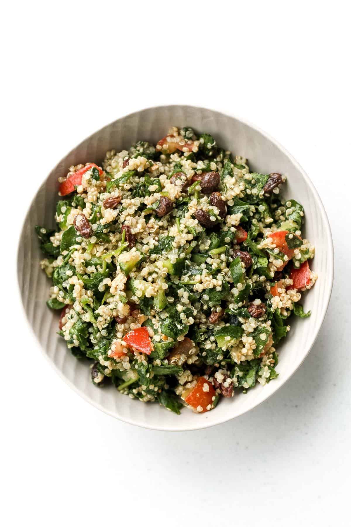Take a bite into this refreshing, gluten-free quinoa and spinach salad bursting with colourful tomatoes, cucumbers and raisins. | aheadofthyme.com