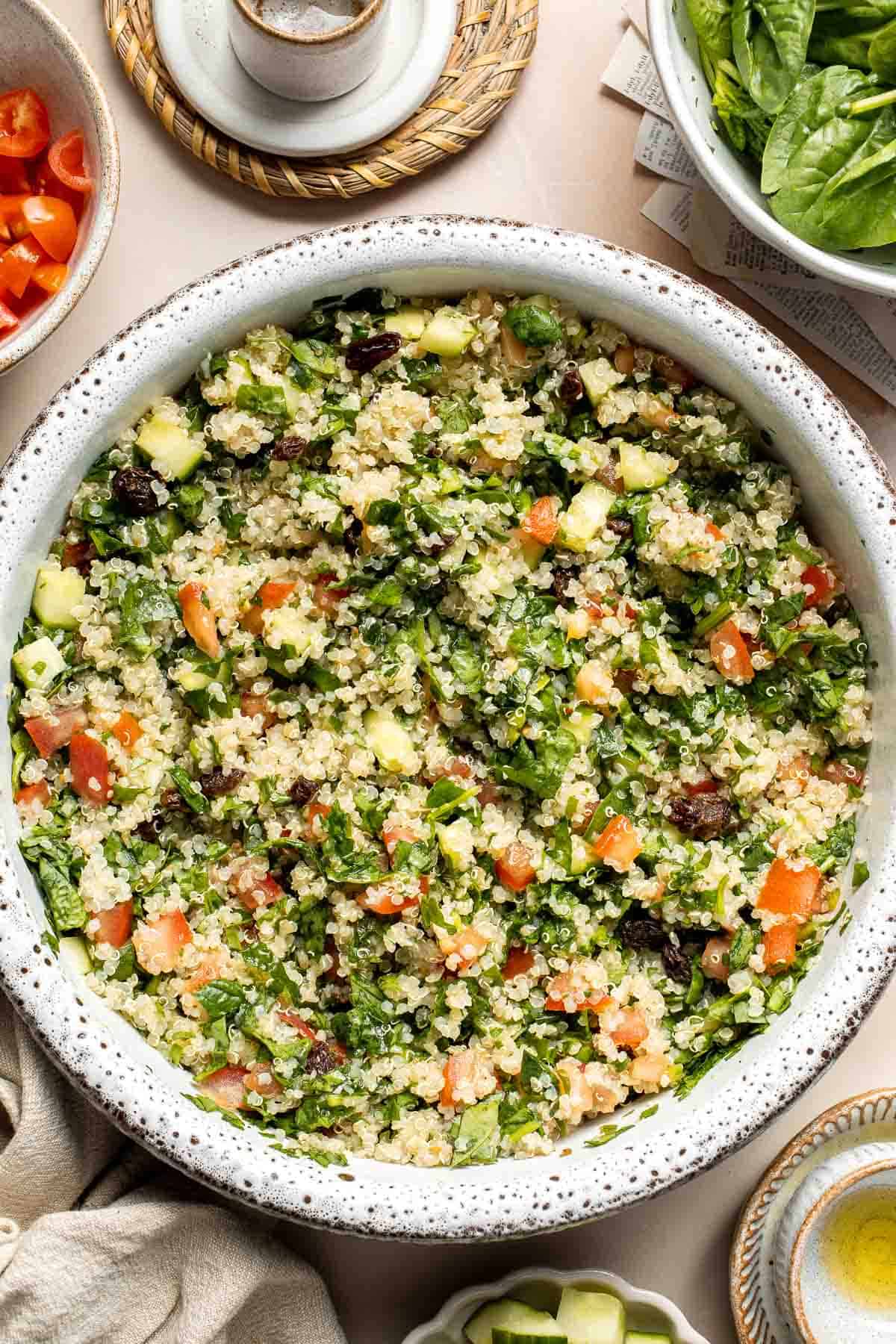 Quinoa Spinach Power Salad is made with tender quinoa, tomatoes, cucumbers, and raisins dressed in a homemade lemon vinaigrette. Gluten-free and vegan too. | aheadofthyme.com