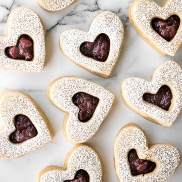 Cute raspberry and white chocolate heart-shaped shortbread cookies literally melt in your mouth. They are the perfect Valentine's Day treat. | aheadofthyme.com