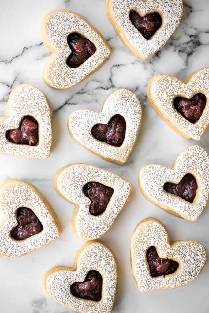 Cute raspberry and white chocolate heart-shaped shortbread cookies literally melt in your mouth. They are the perfect Valentine's Day treat. | aheadofthyme.com