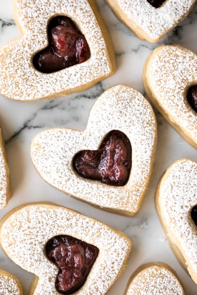 Cute raspberry and white chocolate heart-shaped shortbread cookies literally melt in your mouth. They are the perfect Valentine's Day treat. | aheadofthyme.com