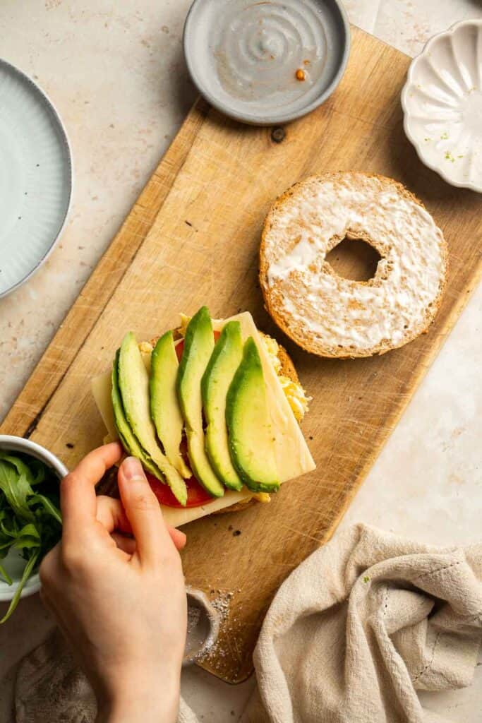 With layers of scrambled eggs, melty cheese, fresh tomato, creamy avocado, and peppery arugula, this Breakfast Bagel is a perfect way to start your day. | aheadofthyme.com