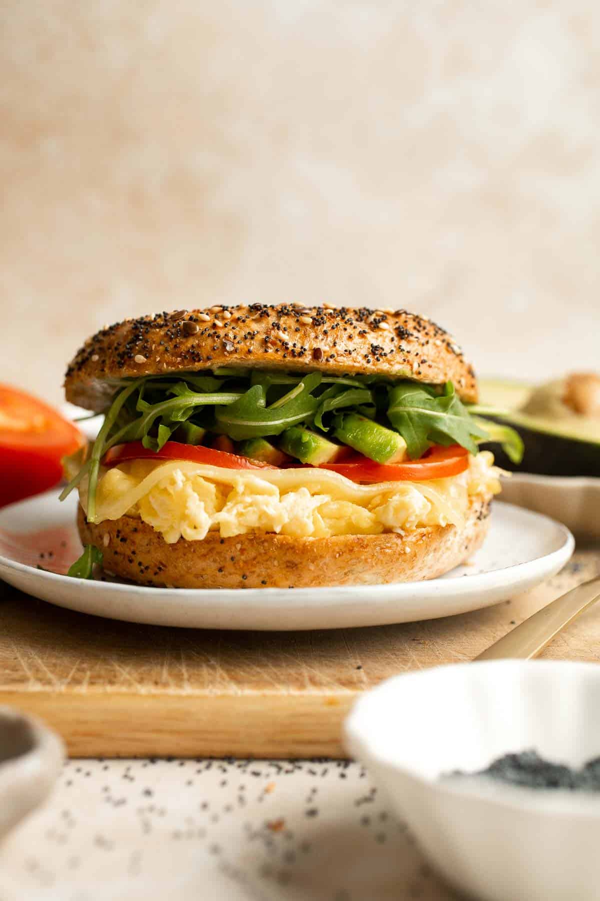 With layers of scrambled eggs, melty cheese, fresh tomato, creamy avocado, and peppery arugula, this Breakfast Bagel is a perfect way to start your day. | aheadofthyme.com