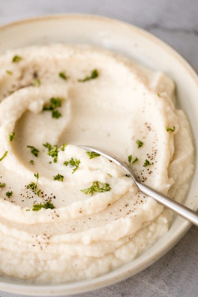 Craving a big serving of mashed potatoes but with a quarter of the calories? Now you can with creamy garlic mashed cauliflower. Ready in just 20 minutes. | aheadofthyme.com