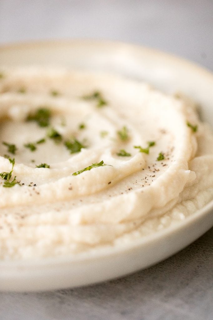 Craving a big serving of mashed potatoes but with a quarter of the calories? Now you can with creamy garlic mashed cauliflower. Ready in just 20 minutes. | aheadofthyme.com