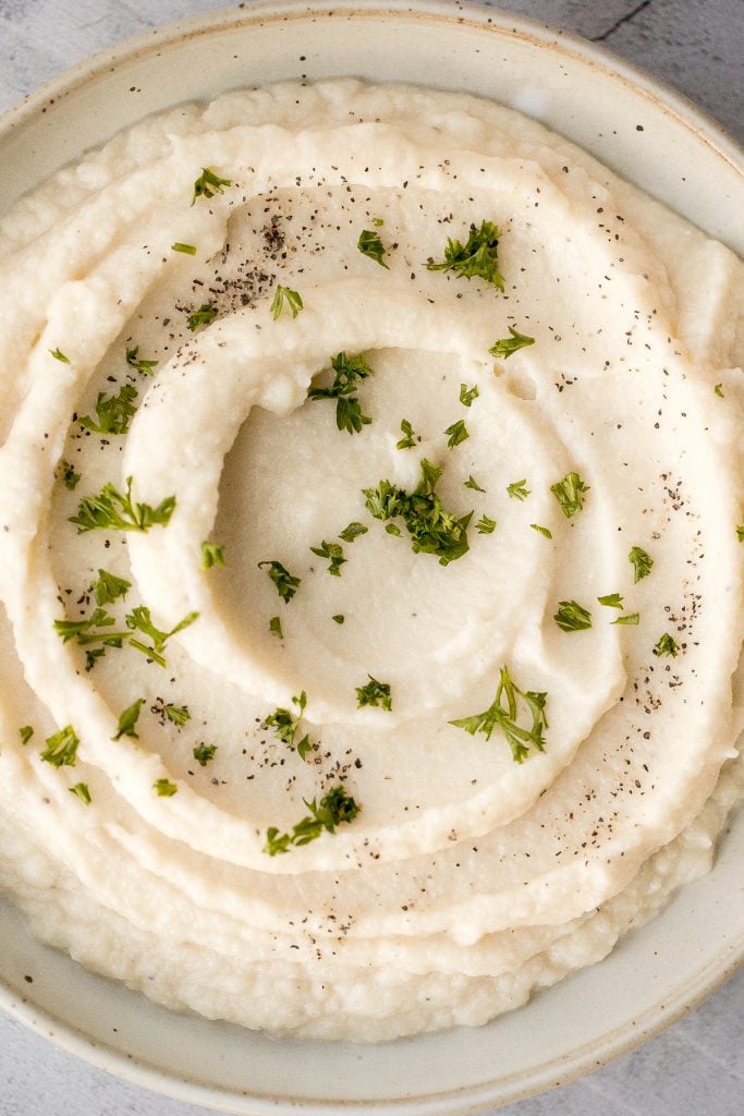 Craving a big serving of mashed potatoes but with a quarter of the calories? Now you can with creamy garlic mashed cauliflower. Ready in just 20 minutes. | aheadofthyme.com