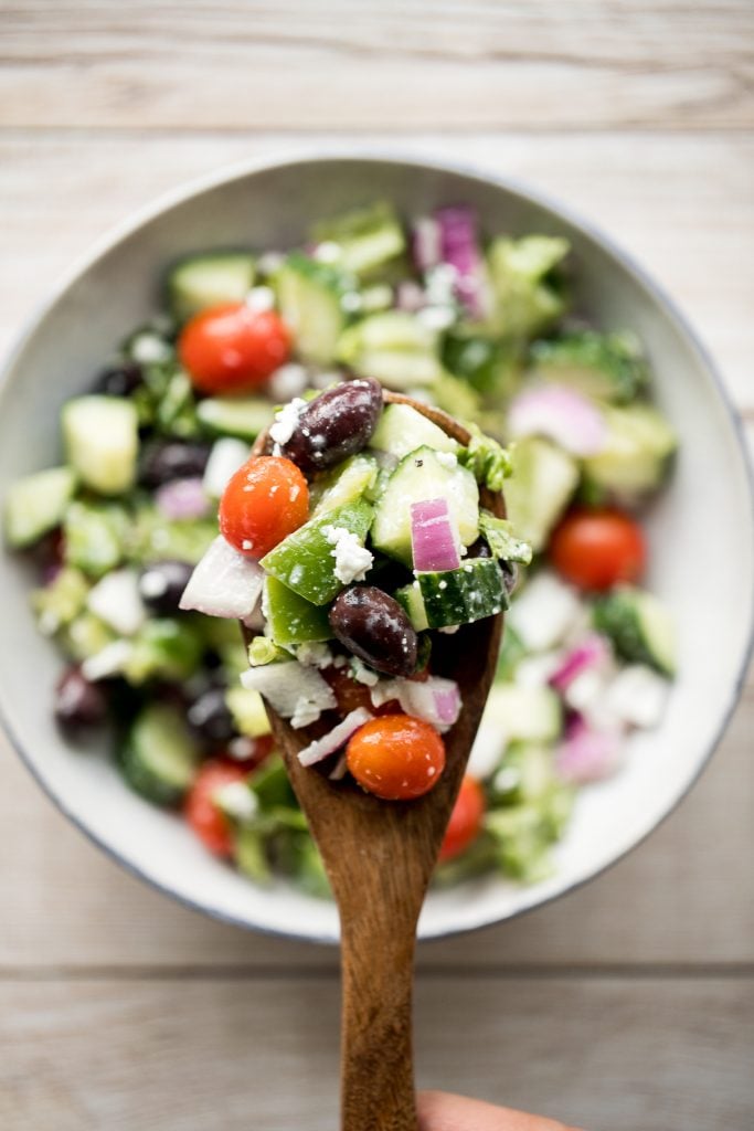 The perfect Greek salad with fresh tomatoes, cucumbers, red onions, green peppers, romaine lettuce, olives and feta cheese tossed in a lemon vinaigrette. | aheadofthyme.com