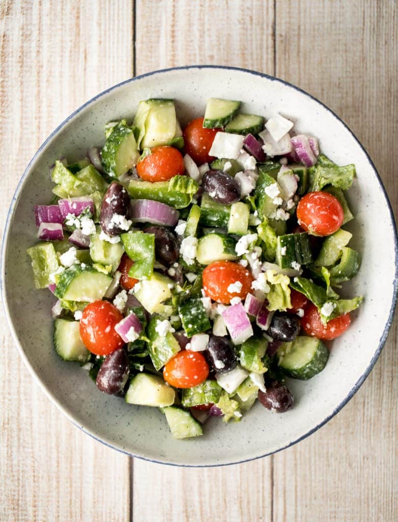 The perfect Greek salad with fresh tomatoes, cucumbers, red onions, green peppers, romaine lettuce, olives and feta cheese tossed in a lemon vinaigrette. | aheadofthyme.com