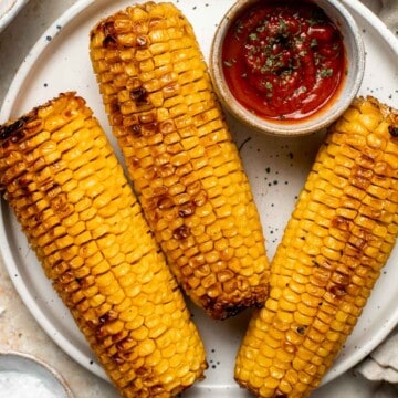 Oven-roasted corn on the cob with homemade garlic butter is buttery, juicy, crunchy, and perfectly charred on the outside — without a grill. | aheadofthyme.com