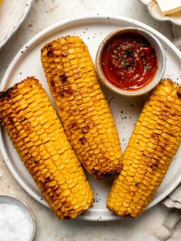 Oven-roasted corn on the cob with homemade garlic butter is buttery, juicy, crunchy, and perfectly charred on the outside — without a grill. | aheadofthyme.com