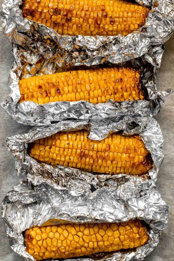 Oven-roasted corn on the cob with homemade garlic butter is buttery, juicy, crunchy, and perfectly charred on the outside — without a grill. | aheadofthyme.com