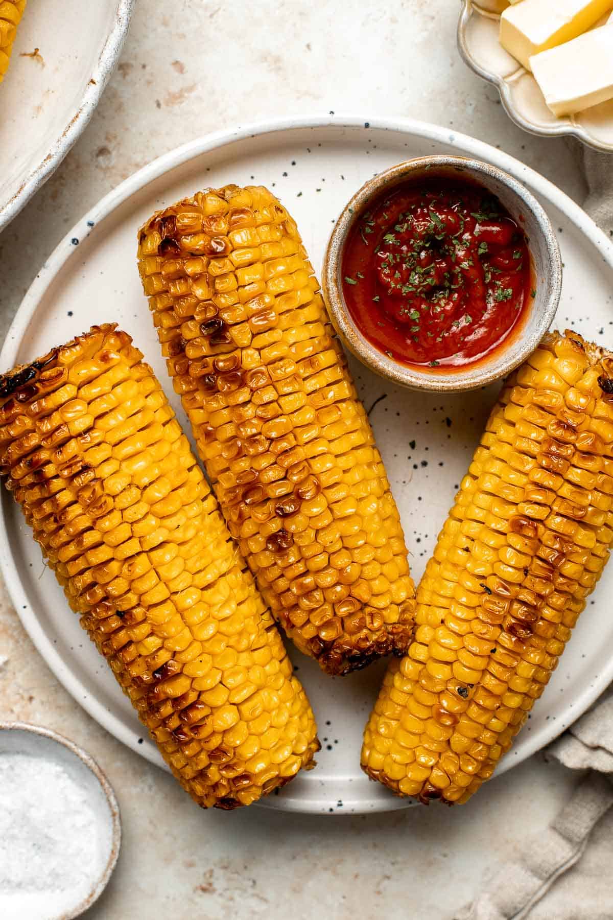 Oven-roasted corn on the cob with homemade garlic butter is buttery, juicy, crunchy, and perfectly charred on the outside — without a grill. | aheadofthyme.com