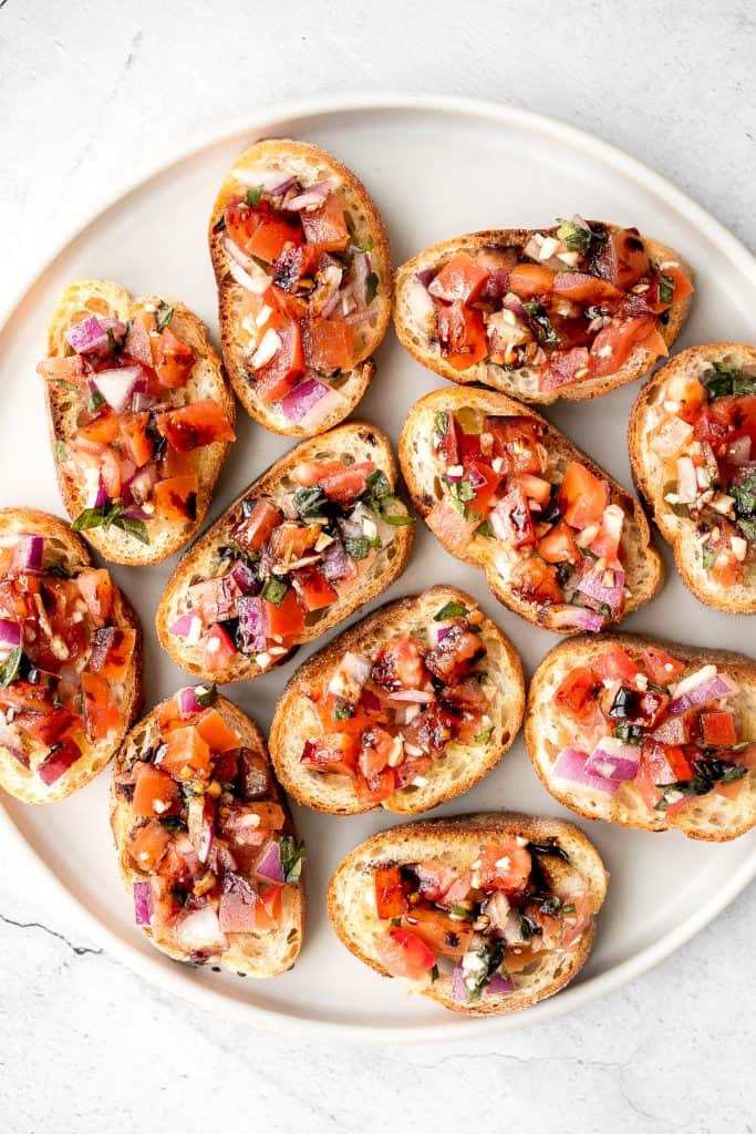 Tomato bruschetta with balsamic glaze is an easy Italian appetizer topped with tomatoes, onions, garlic, basil and olive oil. Delicious, fresh and simple. | aheadofthyme.com