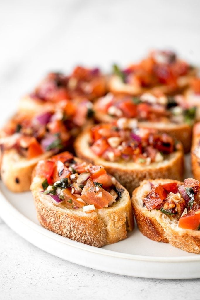 Tomato bruschetta with balsamic glaze is an easy Italian appetizer topped with tomatoes, onions, garlic, basil and olive oil. Delicious, fresh and simple. | aheadofthyme.com