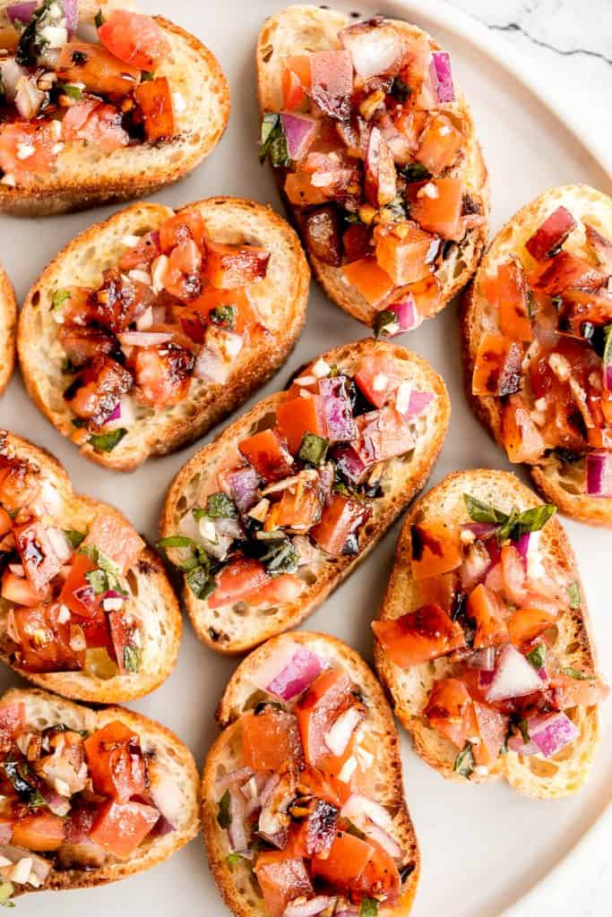 Tomato bruschetta with balsamic glaze is an easy Italian appetizer topped with tomatoes, onions, garlic, basil and olive oil. Delicious, fresh and simple. | aheadofthyme.com
