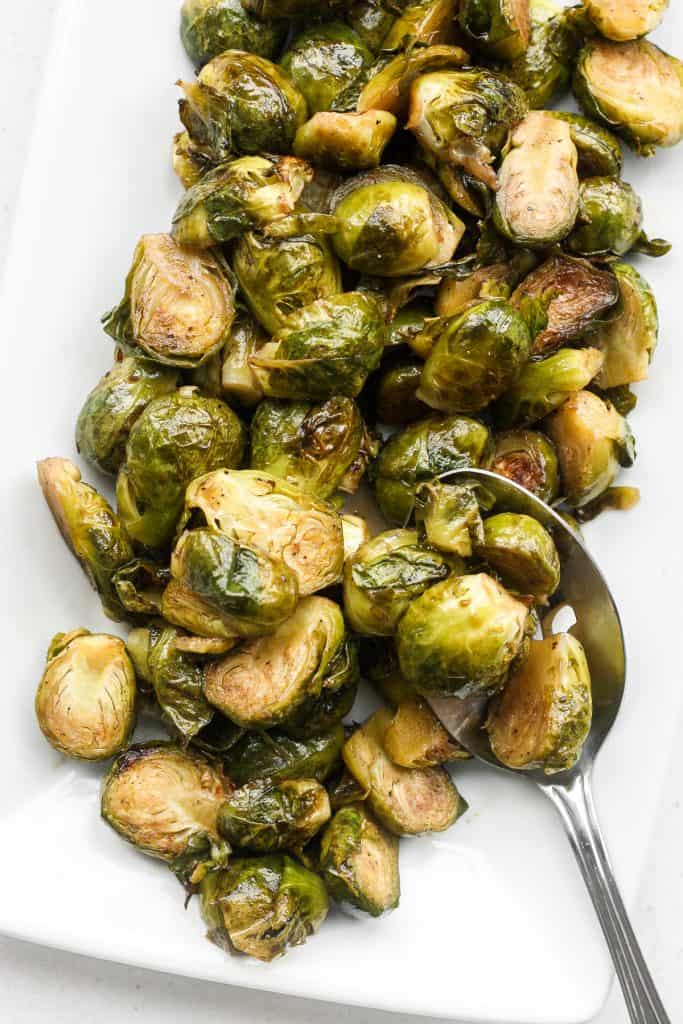 Tender and caramelized, easy roasted brussels sprouts tossed in balsamic vinegar and honey is a classic household favourite to serve on your holiday table. | aheadofthyme.com