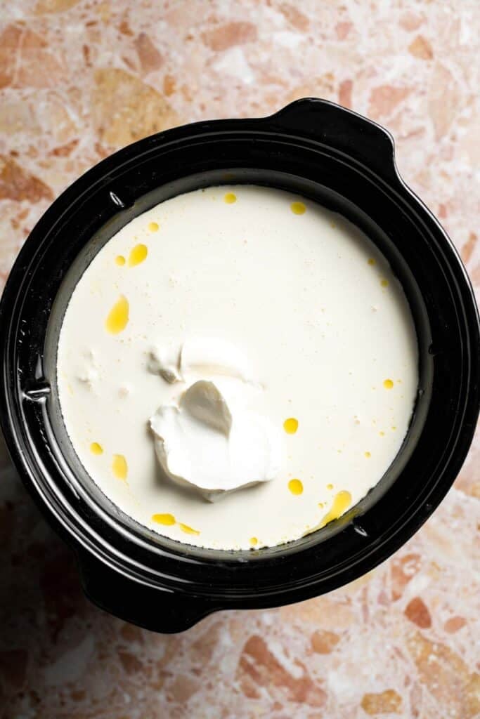 Creamy slow cooker loaded baked potato soup made with tender potatoes, cheddar cheese, sour cream, and topped with bacon. An easy comfort food recipe. | aheadofthyme.com