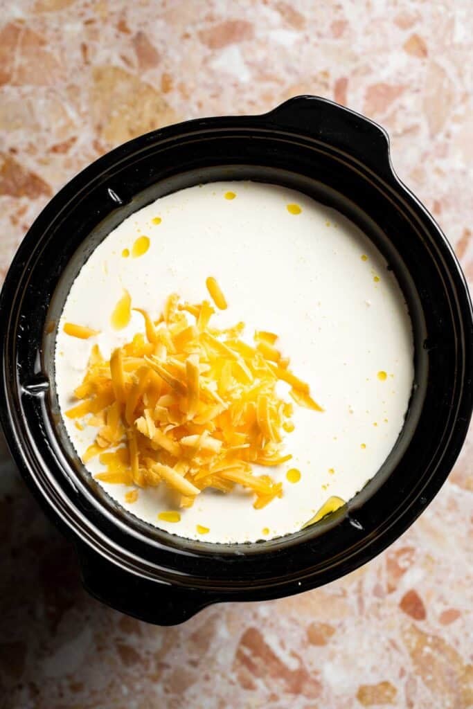 Creamy slow cooker loaded baked potato soup made with tender potatoes, cheddar cheese, sour cream, and topped with bacon. An easy comfort food recipe. | aheadofthyme.com