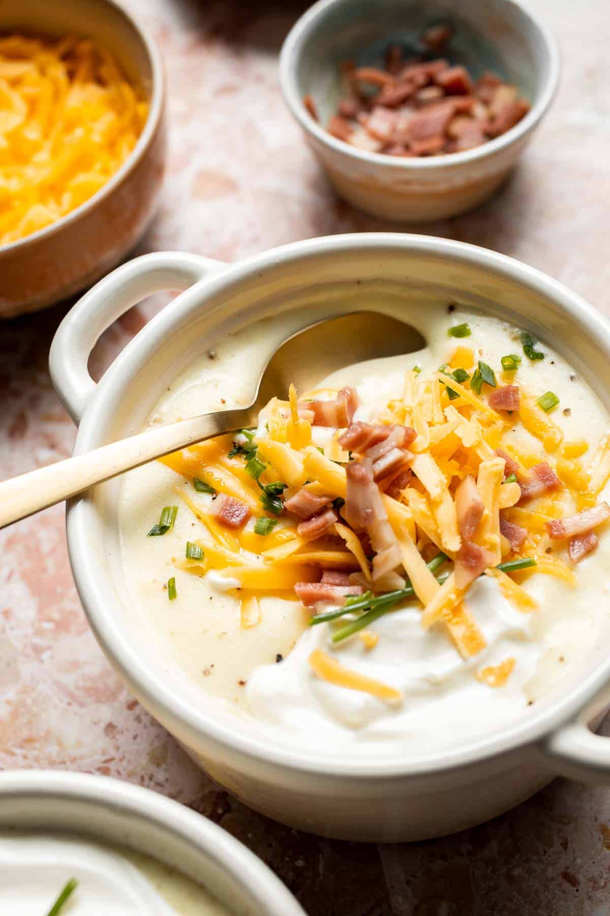 Creamy slow cooker loaded baked potato soup made with tender potatoes, cheddar cheese, sour cream, and topped with bacon. An easy comfort food recipe. | aheadofthyme.com