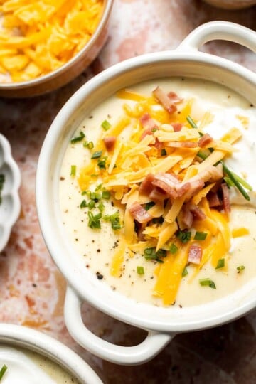 Creamy slow cooker loaded baked potato soup made with tender potatoes, cheddar cheese, sour cream, and topped with bacon. An easy comfort food recipe. | aheadofthyme.com