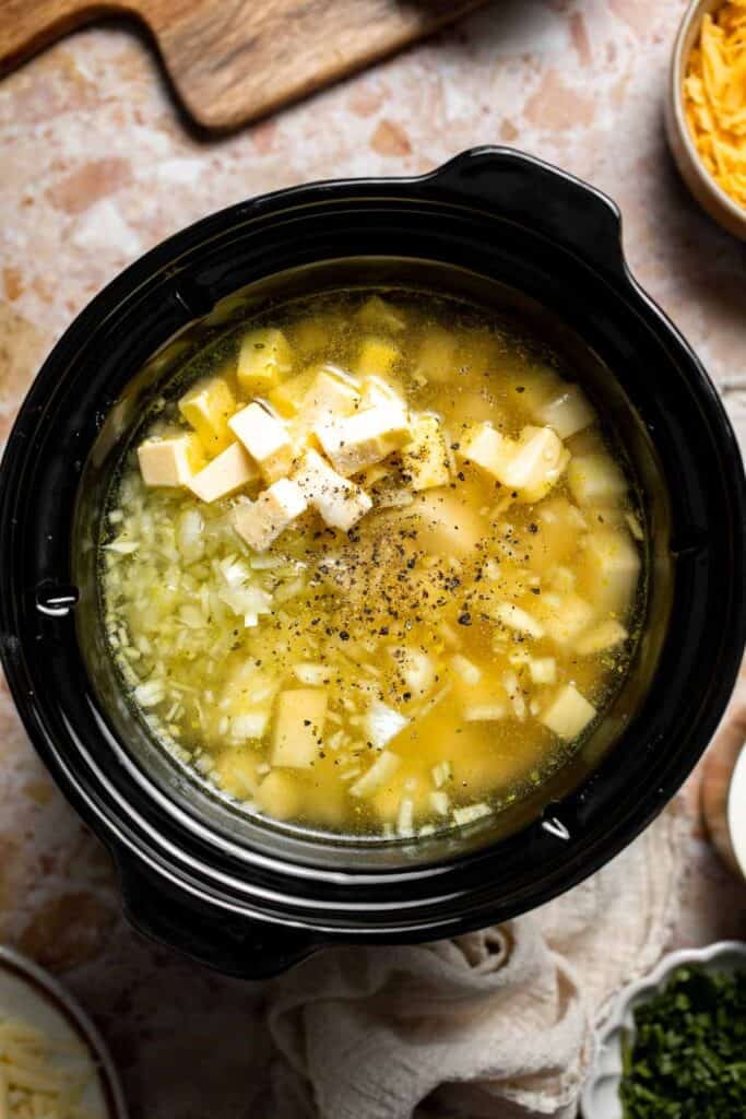 Creamy slow cooker loaded baked potato soup made with tender potatoes, cheddar cheese, sour cream, and topped with bacon. An easy comfort food recipe. | aheadofthyme.com
