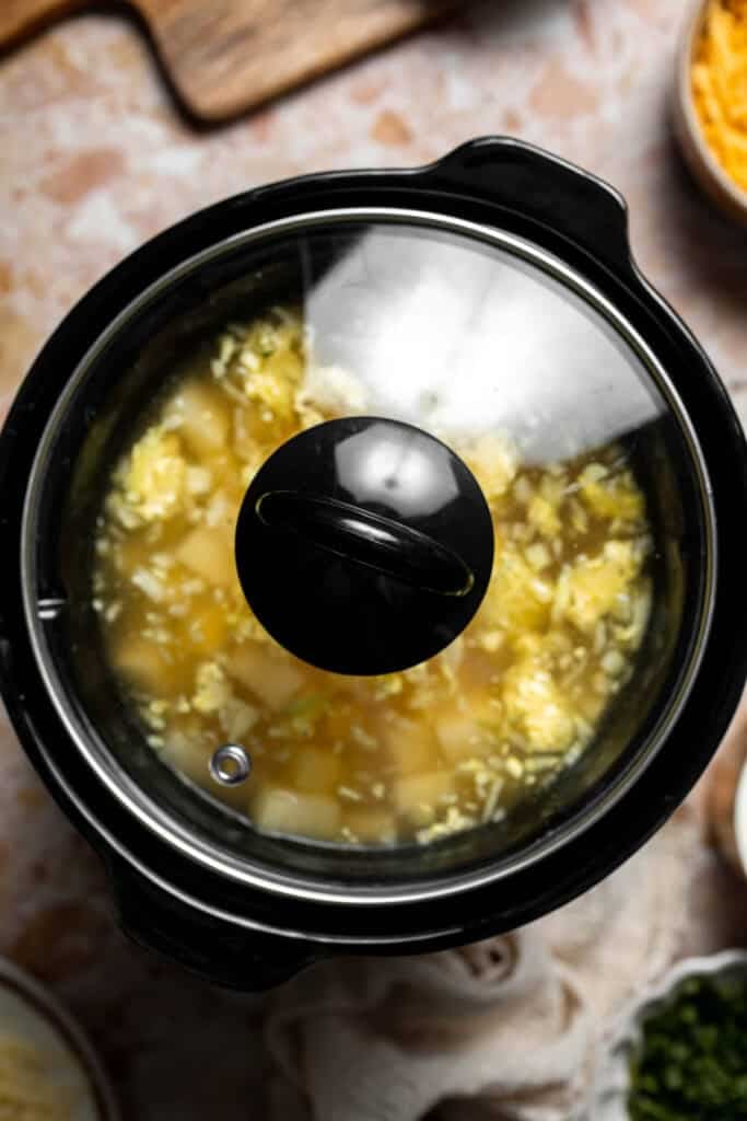 Creamy slow cooker loaded baked potato soup made with tender potatoes, cheddar cheese, sour cream, and topped with bacon. An easy comfort food recipe. | aheadofthyme.com