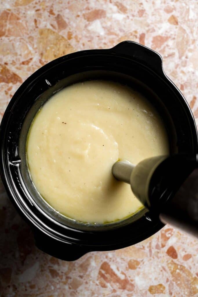 Creamy slow cooker loaded baked potato soup made with tender potatoes, cheddar cheese, sour cream, and topped with bacon. An easy comfort food recipe. | aheadofthyme.com