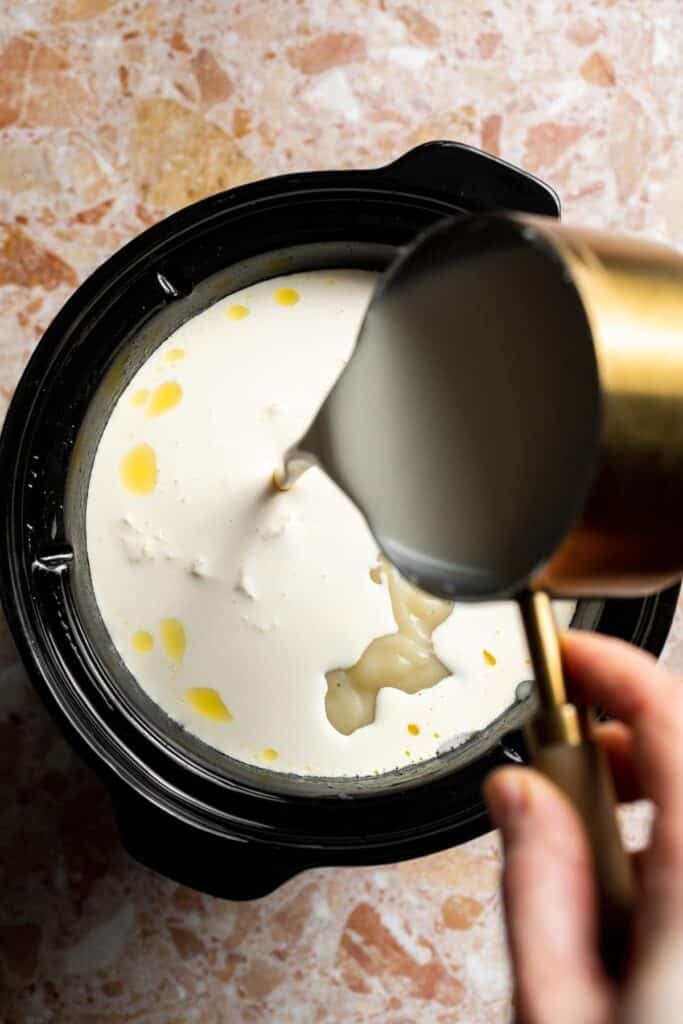 Creamy slow cooker loaded baked potato soup made with tender potatoes, cheddar cheese, sour cream, and topped with bacon. An easy comfort food recipe. | aheadofthyme.com