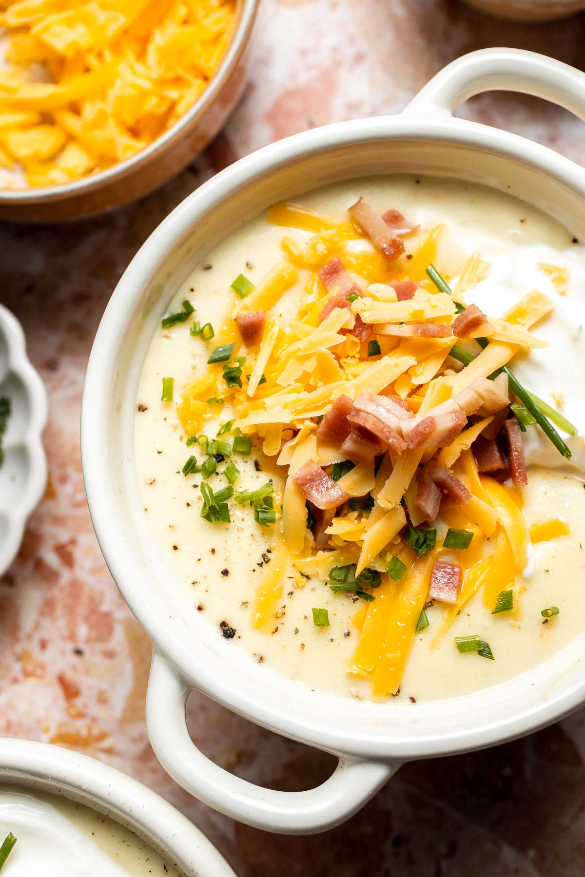 Creamy slow cooker loaded baked potato soup made with tender potatoes, cheddar cheese, sour cream, and topped with bacon. An easy comfort food recipe. | aheadofthyme.com