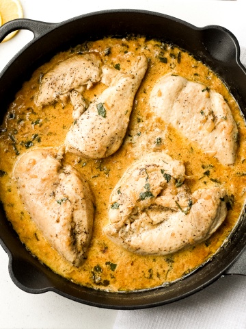 Delicious creamy skillet chicken with lemon garlic sauce is a one-skillet meal that is ready in 30 minutes. It's garlicky, saucy, creamy, and so flavourful. | aheadofthyme.com
