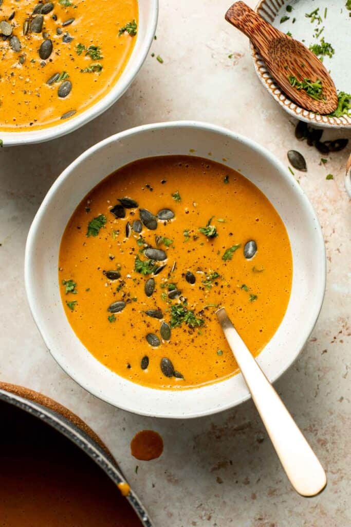 Roasted carrot and ginger soup is rich, velvety, creamy, flavorful, and delicious. This healthy vegetarian soup is quick and easy to make in 30 minutes. | aheadofthyme.com