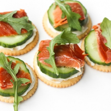 Smoked salmon and cream cheese cracker bites are topped with cucumber and argula to make the perfect bite-size snacks. | aheadofthyme.com