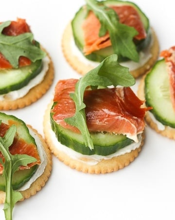 Smoked salmon and cream cheese cracker bites are topped with cucumber and argula to make the perfect bite-size snacks. | aheadofthyme.com