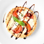 Looking for the perfect appetizer or light lunch? Try a tomato and mozzarella tart topped with basil and a drizzle of pomegranate molasses! | aheadofthyme.com