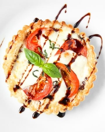 Looking for the perfect appetizer or light lunch? Try a tomato and mozzarella tart topped with basil and a drizzle of pomegranate molasses! | aheadofthyme.com