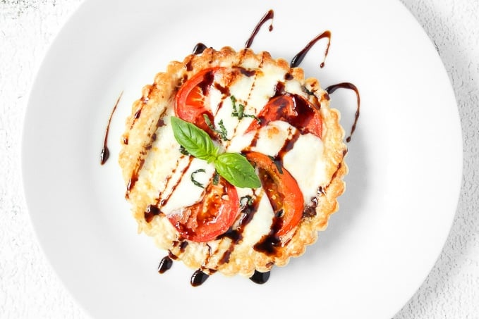 Looking for the perfect appetizer or light lunch? Try a tomato and mozzarella tart topped with basil and a drizzle of pomegranate molasses! | aheadofthyme.com