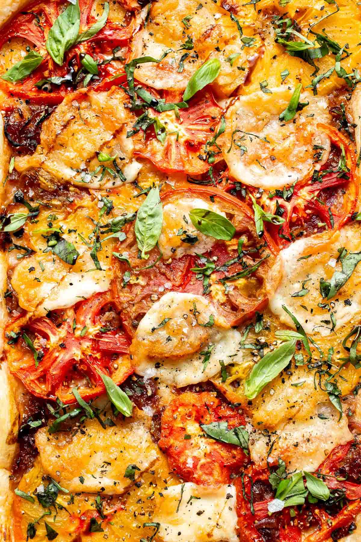 Close-up of Tomato Puff Pastry Tart with juicy tomatoes, melted mozzarella, basil, and flaky pastry.