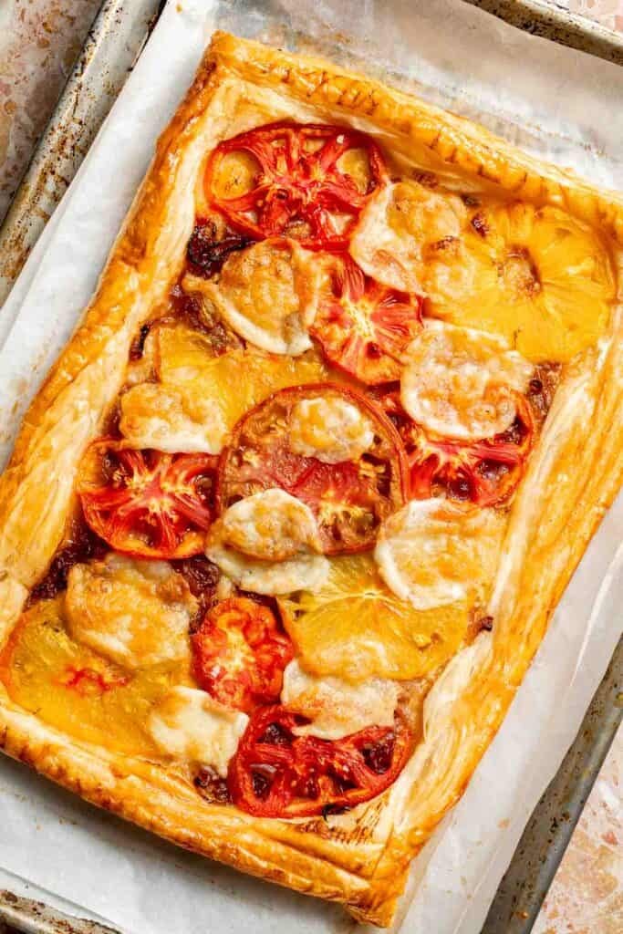 Freshly baked Tomato Puff Pastry Tart with melted mozzarella and golden pastry.