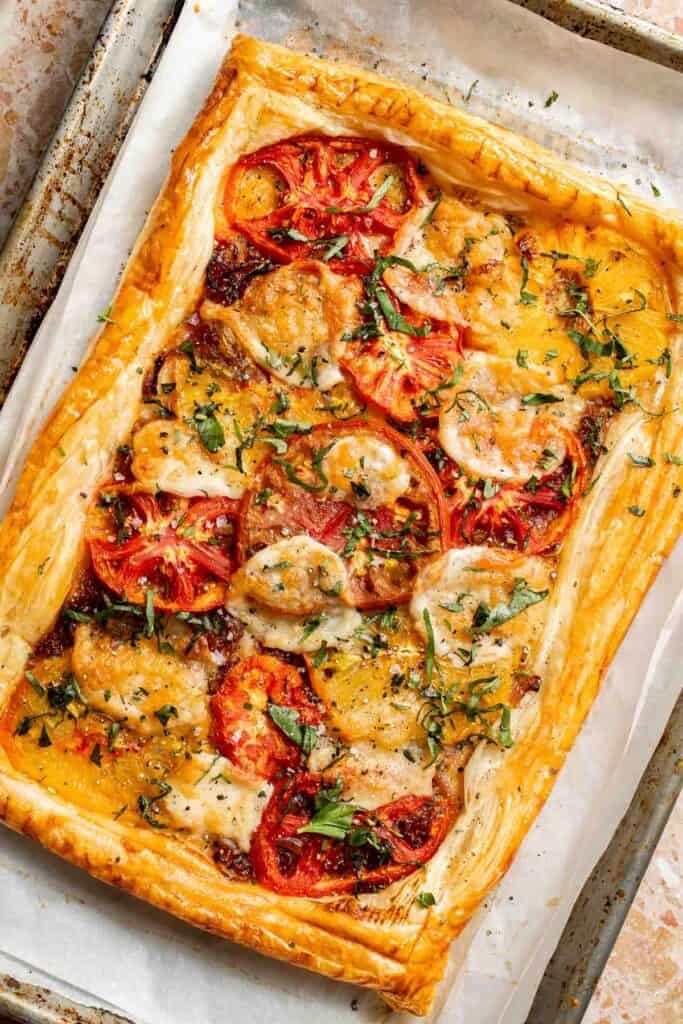 Tomato Puff Pastry Tart with mozzarella, fresh basil, and balsamic glaze ready to serve.