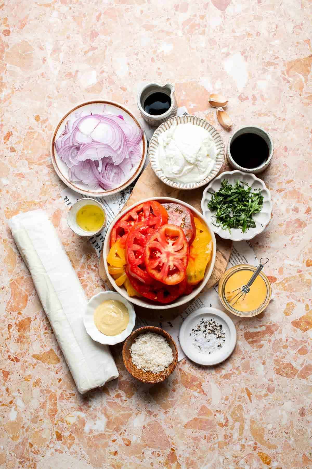 Ingredients for Tomato Puff Pastry Tart with mozzarella, tomatoes, red onion, Parmesan, Dijon mustard, basil, and balsamic vinegar.