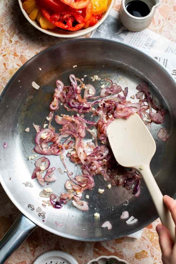 Lightly caramelized red onions in a skillet.