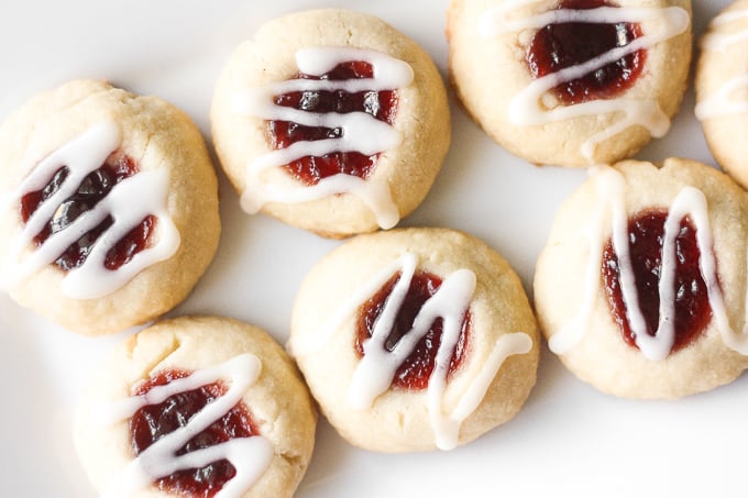Soft, buttery, melt-in-your mouth jam-filled thumbprint cookies with almond glaze are the cutest, festive treat to make. | aheadofthyme.com