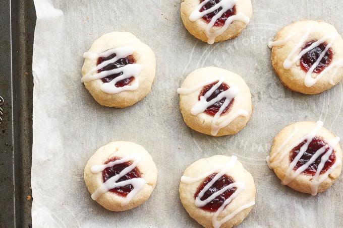 Soft, buttery, melt-in-your mouth jam-filled thumbprint cookies with almond glaze are the cutest, festive treat to make. | aheadofthyme.com